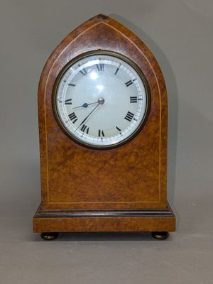 une petite horloge en bois avec des chiffres romains