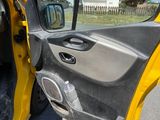 a yellow car with the door open on the street