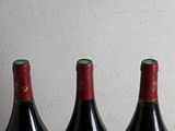 three bottles of wine are lined up on a table