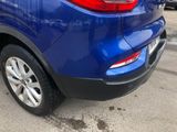 the rear end of a blue car parked in a parking lot