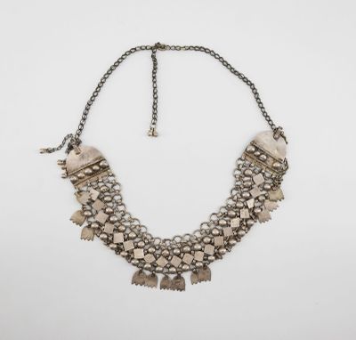 the necklace is made of metal and has a chain with beads on it