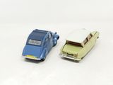 two toy cars sitting next to each other on a white surface