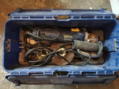 une boîte bleue contenant des outils, posée par terre