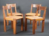 trois chaises en bois placées les unes à côté des autres sur un fond gris