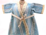 une robe bleue posée sur un mannequin en bois, sur fond blanc