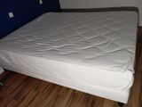 a bed with a white mattress on it in a room
