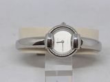 a white watch with a silver band on a white surface