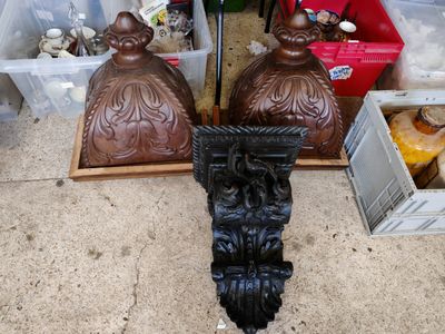 deux statues brunes assises par terre l'une à côté de l'autre
