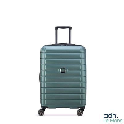 une valise verte à roulettes sur fond blanc