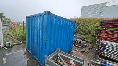 a blue container sitting in the middle of a parking lot