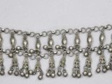 gros plan d'un collier en argent sur une surface blanche