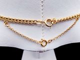 a close up of a mannequin torso with a gold chain on it