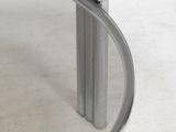 a glass table with a metal base and a mirror on it