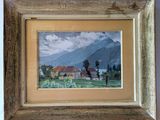 framed picture of a painting of a house in a field with mountains in the background