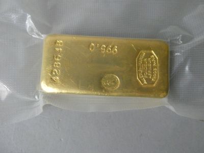 a gold bar in a plastic bag on a white surface
