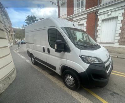 La petite camionnette blanche est garée sur le bord de la rue.