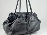 the large black bag is being held by a hand