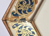a mirror with a gold and red design on it