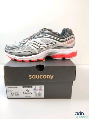 des chaussures de course Saucony dans une boîte posée sur une surface blanche