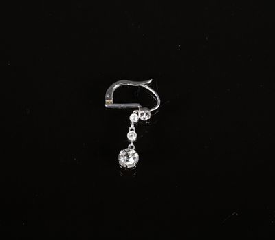 un gros plan sur une paire de piercings aux oreilles sur un fond noir