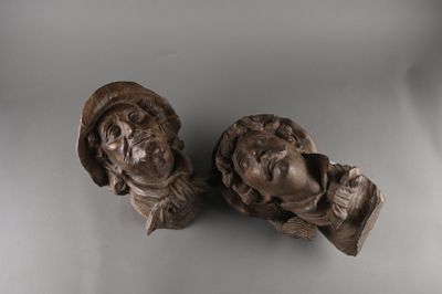 pair of carved busts of two men with hats on each of them