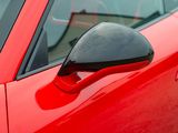 a close up of a red car ' s side view mirror