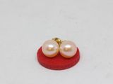pair of pink pearl earrings on a red sponge