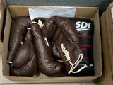 deux gants de boxe dans une boîte posée par terre