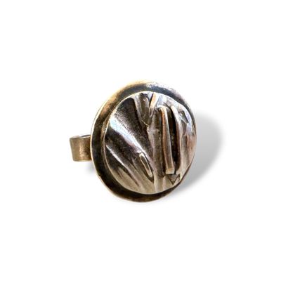 une image montrant un gros plan d'une bague en argent posée sur une surface blanche