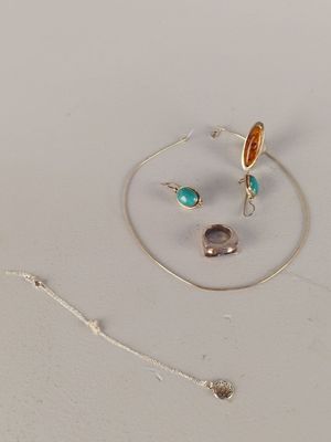 deux bagues et un collier posés sur une surface blanche