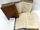 trois vieux livres posés sur une table l'un à côté de l'autre