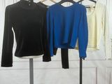 three shirts are hanging on a clothes rack in front of a white wall