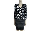 Le mannequin porte une robe noire et blanche à pois.