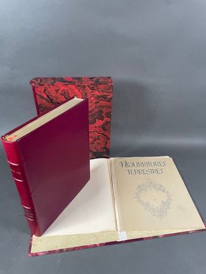 un livre rouge ouvert posé sur une table, à côté d'un livre rouge