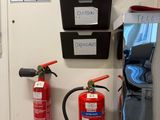 two fire extinguisors on the wall next to a door