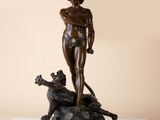 bronze statue of a woman with a dog on a rock