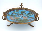 une assiette bleue et dorée ornée d'un oiseau et de fleurs