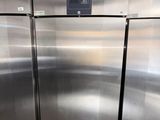 two stainless steel refrigerators in a kitchen with a sign on the door
