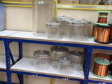 many different types of wires on the shelves in the room