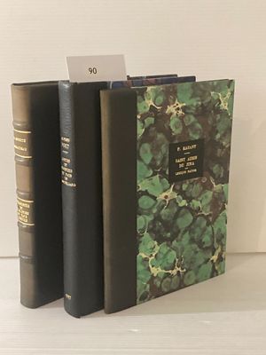 trois livres posés sur une table blanche