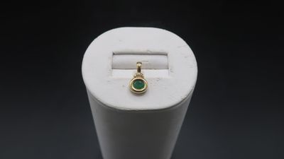 a close up of a ring with a green stone in it