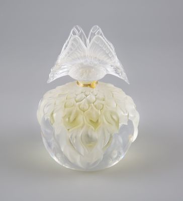 flacon de parfum en verre translucide contenant des fleurs blanches, sur fond blanc