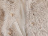 a close up of a fur coat on a hanger on a wall