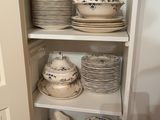 many plates and bowls on the shelves in the kitchen