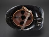 an old black helmet with a leather strap and a metal buckle