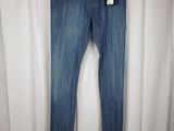 a pair of jeans hanging on a hanger on a white curtain