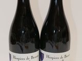 deux bouteilles de vin rouge posées sur une table blanche