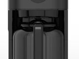 une cafetière noire posée sur un plan de travail blanc