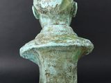 statue of a man ' s head on a bust on a black background