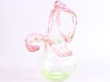 un vase en verre contenant une fleur rose